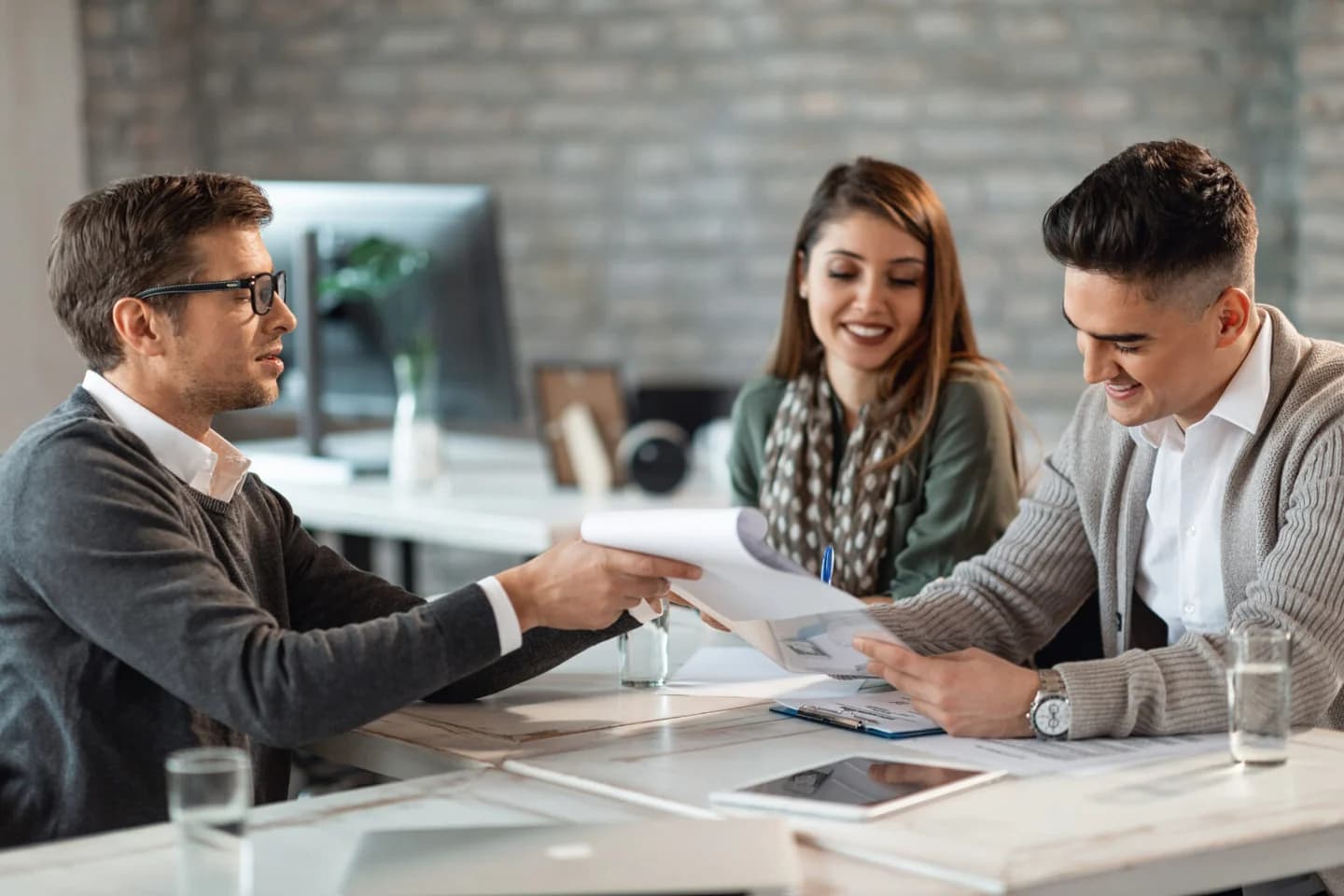 A financial adviser discussing documents with two clients